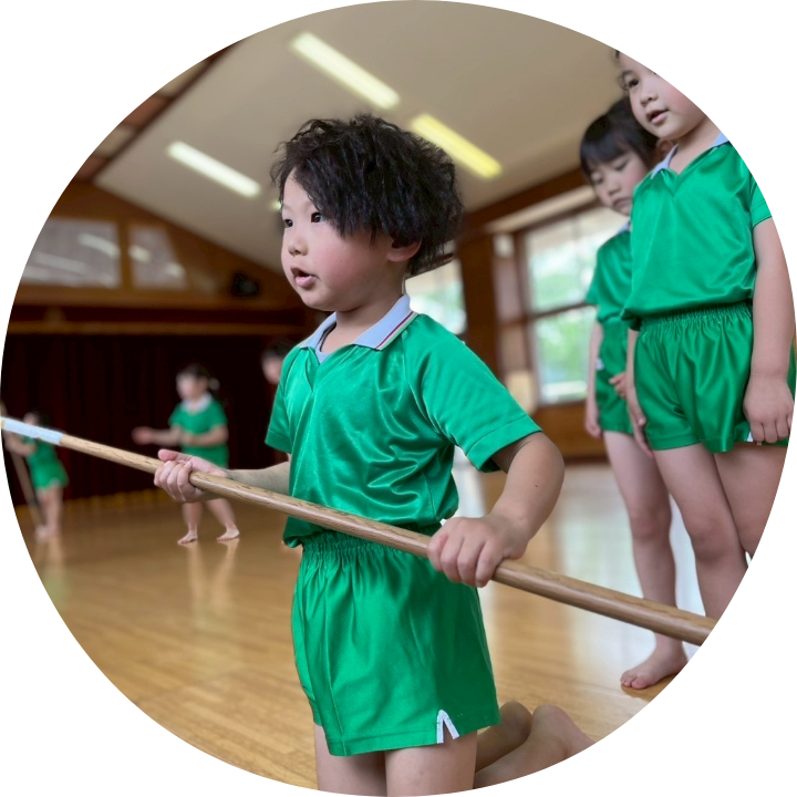 棒を持つ園児